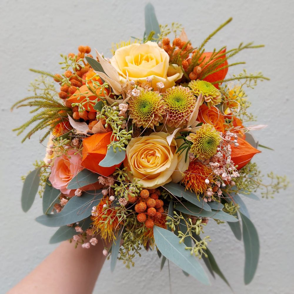 Brautstrauß in Apricot und Orange mit Rosen, Leucospermum und Eukalyptus