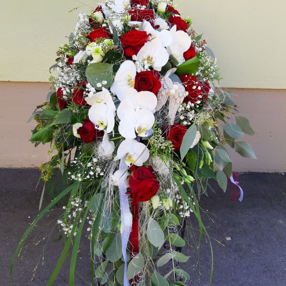 Gesteck mit roten Rosen, weißen Orchideen und Schleierkraut